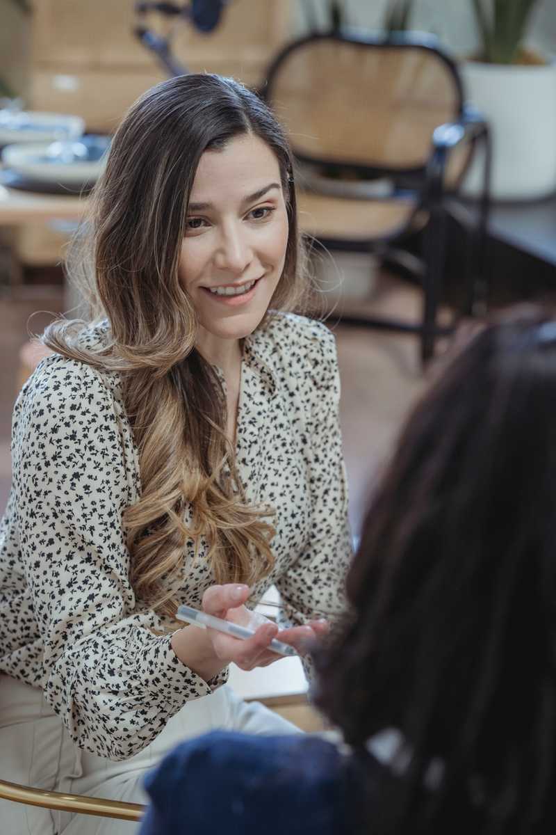 Jeune femme souriante parlant à une autre femme en entretien d'embauche. 