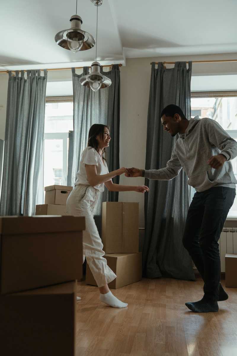 Un couple dansant dans un salon avec des cartons